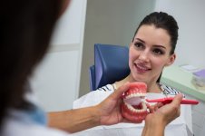 dentist-showing-set-model-teeth-patient_107420-65670.jpg